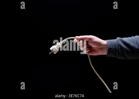 Hand holding cable with power connector Stock Photo