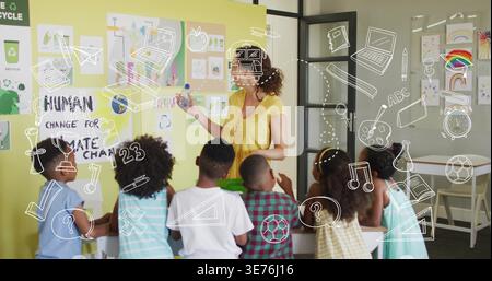 Adult teacher in yellow top holding object and instructing children at table with recycling poster Stock Photo