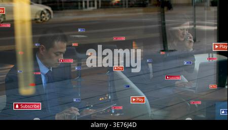 Diverse coworkers in suits reacting to icons, using tablet,laptop and phone for work at cafe window Stock Photo