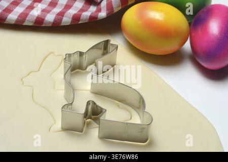 Rolled dough with bunny cookie cutter and easter eggs Stock Photo