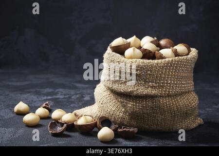 Macadamia nuts in a bag on a black table. piles or piles of macadamia nuts Stock Photo
