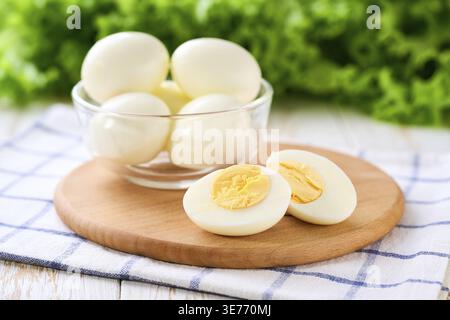 Boiled chicken eggs peeled and cut in half on a light kitchen table Stock Photo
