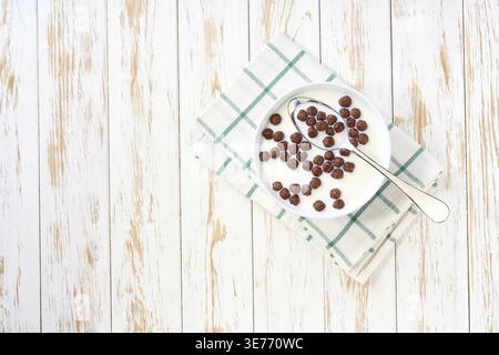 Quick breakfast for kids: chocolate corn balls with milk. Dry breakfast. Making a healthy breakfast cereal using chocolate corn balls and milk Stock Photo