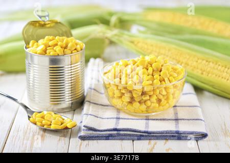 Canned young corn grain in a clear glass bowl on a white table, selective focus Stock Photo