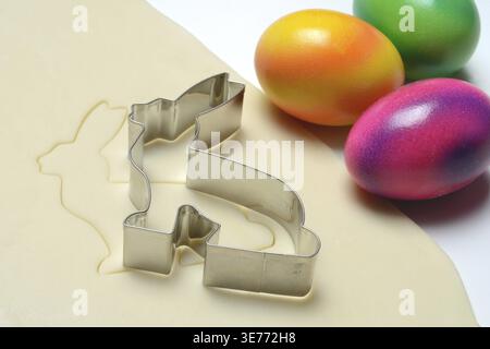 Rolled dough with bunny cookie cutter and easter eggs Stock Photo