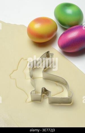 Rolled dough with bunny cookie cutter and easter eggs Stock Photo