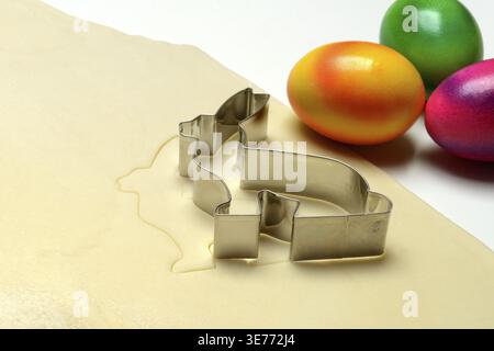 Rolled dough with bunny cookie cutter and easter eggs Stock Photo