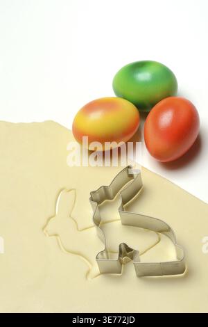 Rolled dough with bunny cookie cutter and easter eggs Stock Photo