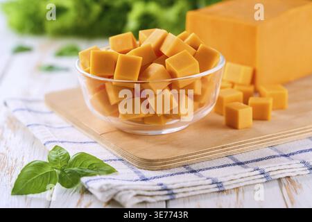 Glass Bowl with Cheddar Cheese Cubes on White Wooden Table, Selective Focus Stock Photo