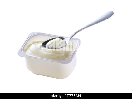 Open packing with yoghurt or tasty dessert in a white plastic cup with a spoon isolated on a white background. Top view Stock Photo