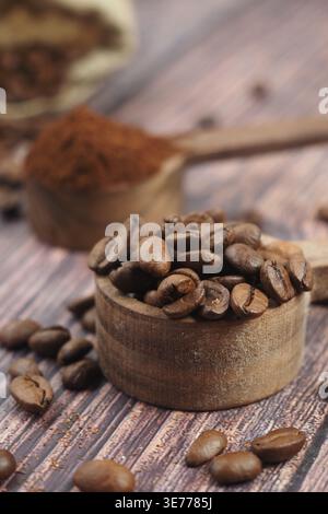 Coffee beans and ground coffee on wooden table Stock Photo