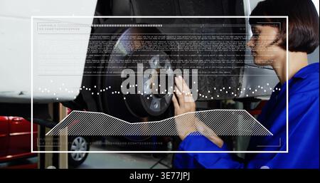 Inspecting female mechanic in blue coverall checking brake rotor and hub on lift, HUD, copy space Stock Photo
