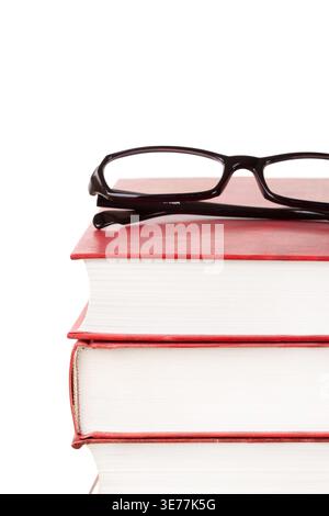 Stack of books with glasses on top front view isolated white background macro vertical Stock Photo