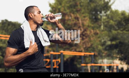 Sporty man drinking water after workout outside Stock Photo