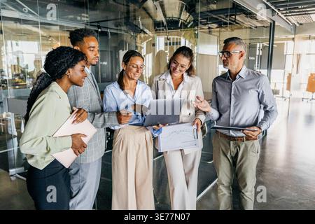 Development team reviews demonstration while smiling and planning features Stock Photo