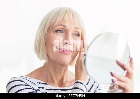 Senior woman touching her soft face skin Stock Photo