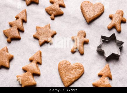 Gingerbread cookies and metal cutter on paper Stock Photo
