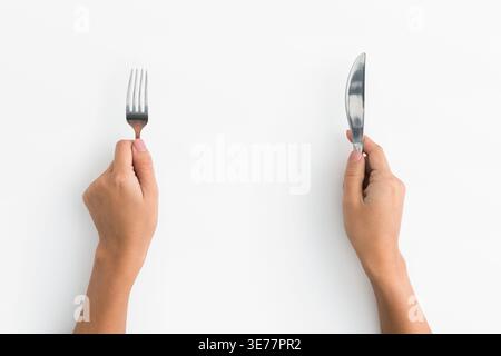 Woman hands holding fork and knife on white background Stock Photo