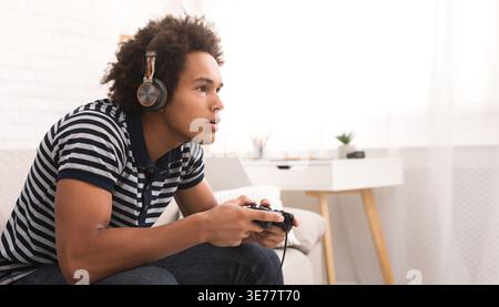 Concentrated teenager playing video games with joystick Stock Photo