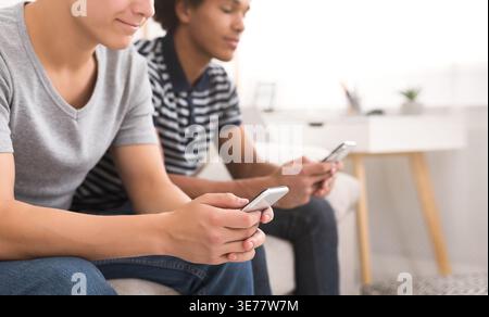 Diverse friends using smartphones while sitting at home Stock Photo