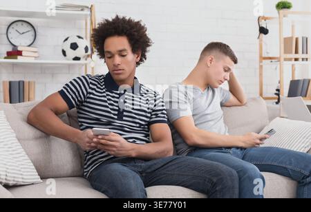 Friends texting on smartphones, don't speak with each other Stock Photo