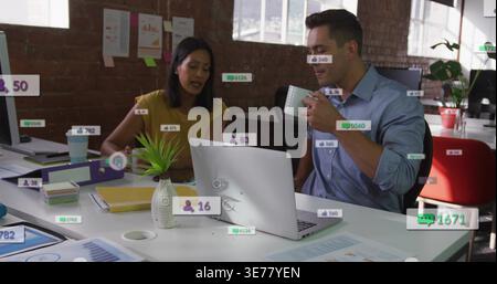 Diverse coworkers in business casual collaborating in modern open office over laptop amid metrics Stock Photo