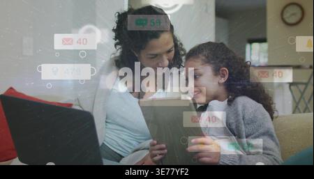 Girl tapping tablet while woman leaning in on couch, animated notifications appearing for education Stock Photo