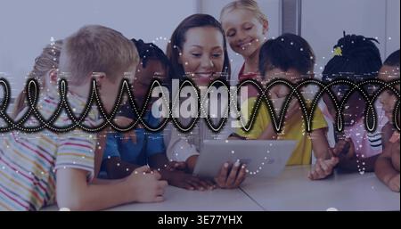 Holding tablet, teacher in cardigan guiding children at classroom table, with waveform overlay Stock Photo