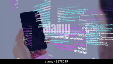 Holding black smartphone in left hand at studio showing code overlay blurred shoulder, copy space Stock Photo