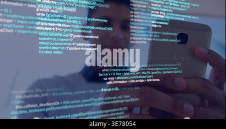 Examining smartphone, male programmer wearing dark top working in dim office with JS code on glass Stock Photo