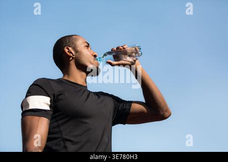 Man resting and drinking water after running Stock Photo