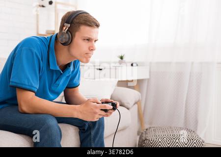 Concentrated guy playing video game with joystick Stock Photo