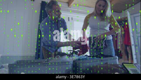 Packing couple in bedroom, man in shirt, woman in jeans folding clothes with suitcase green overlay Stock Photo