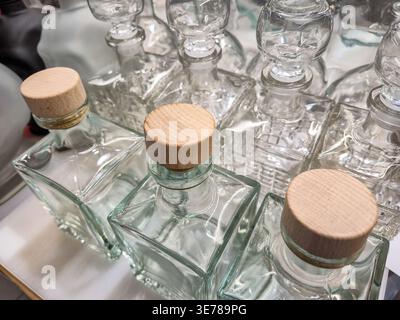 Rows of empty square glass bottles with natural wood caps, ready for filling with liquids or decorative use Stock Photo