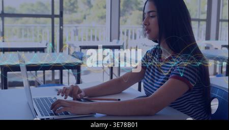 Typing teen student striped tee using laptop in study area, notebook, pencil, waveform, copy space Stock Photo