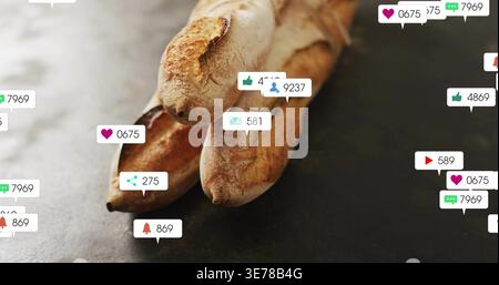 Alerts are popping as notification bubbles over 3 crusty baguettes on slate table, showing buzz Stock Photo