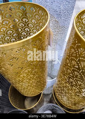 close up view of ornate metal containers featuring delicate floral and fan-shaped perforations, showcasing a luxurious aesthetic Stock Photo