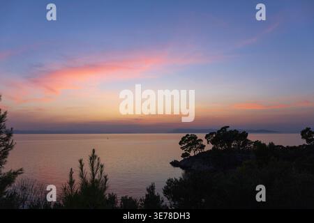 Soft pastel sunset colors over calm Adriatic sea. Peaceful minimal seascape. Stock Photo