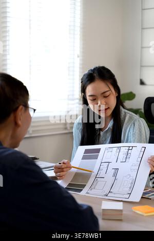 Designers and architects man and woman  are brainstorm discussing revisions to the project's design in the design office. Stock Photo