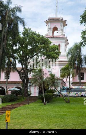 The Hotel das Cataratas, a landmark colonial-style building painted in its distinctive pink and white facade, stands prominently surrounded by lush tr Stock Photo