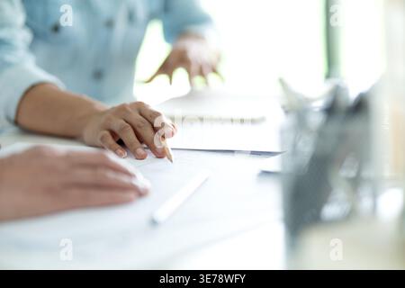 Engineers and architects are looking at the plans of the construction project consulting to plan the work and revising the construction plans to suit Stock Photo