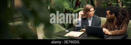 Businesswoman and Man Collaborating on Laptop in Office Stock Photo