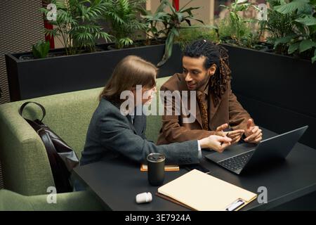 Diverse Business Colleagues Collaborating on Laptop in Office Stock Photo