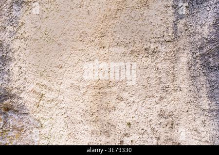 Textured beige plaster wall featuring uneven surfaces and granular details on an architectural structure located in the historic town of Porrentruy, S Stock Photo