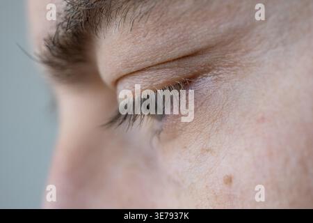 Close up of an unrecognizable Caucasian man looking down with a somber and pensive expression, suggesting a mood of sadness Stock Photo
