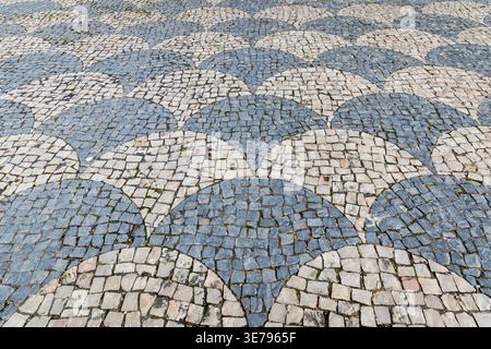 Portuguese cobblestone pavement with wave mosaic pattern Stock Photo