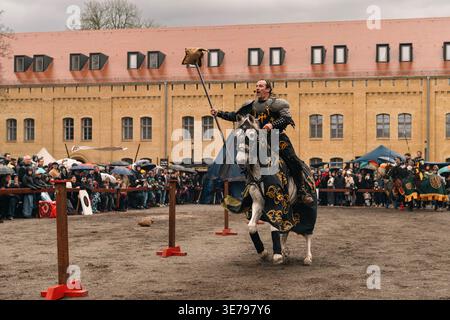 A knight on horseback carries a jousting pole while wearing body armour ...