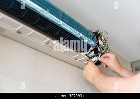 A male air conditioner technician or air conditioning installation. technician is about to repair air conditioning in homes and buildings. Stock Photo