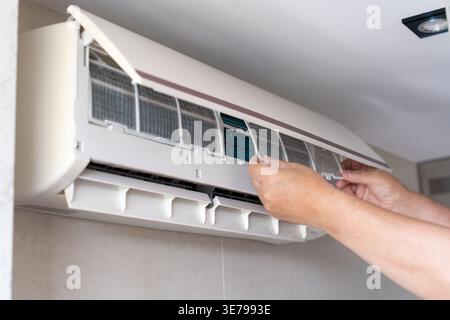 A male air conditioner technician or air conditioning installation. technician is about to repair air conditioning in homes and buildings. Stock Photo