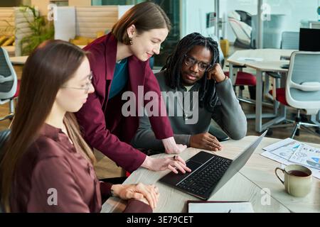 Diverse Coworkers Analyzing Laptop Data for Office Planning Stock Photo